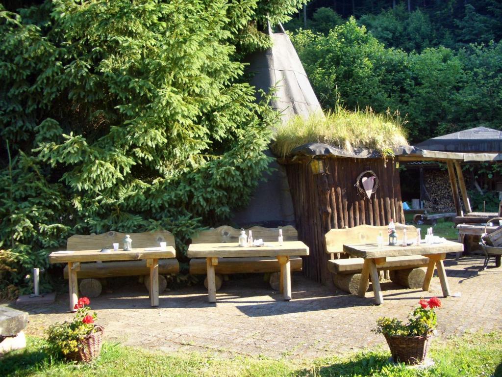 eine Gruppe von Picknicktischen in einem Garten in der Unterkunft Apartmenthaus Jörn in Wieda