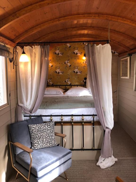 sypialnia z łóżkiem piętrowym z krzesłem i pościelą w obiekcie Roulotte à Honfleur w mieście Honfleur