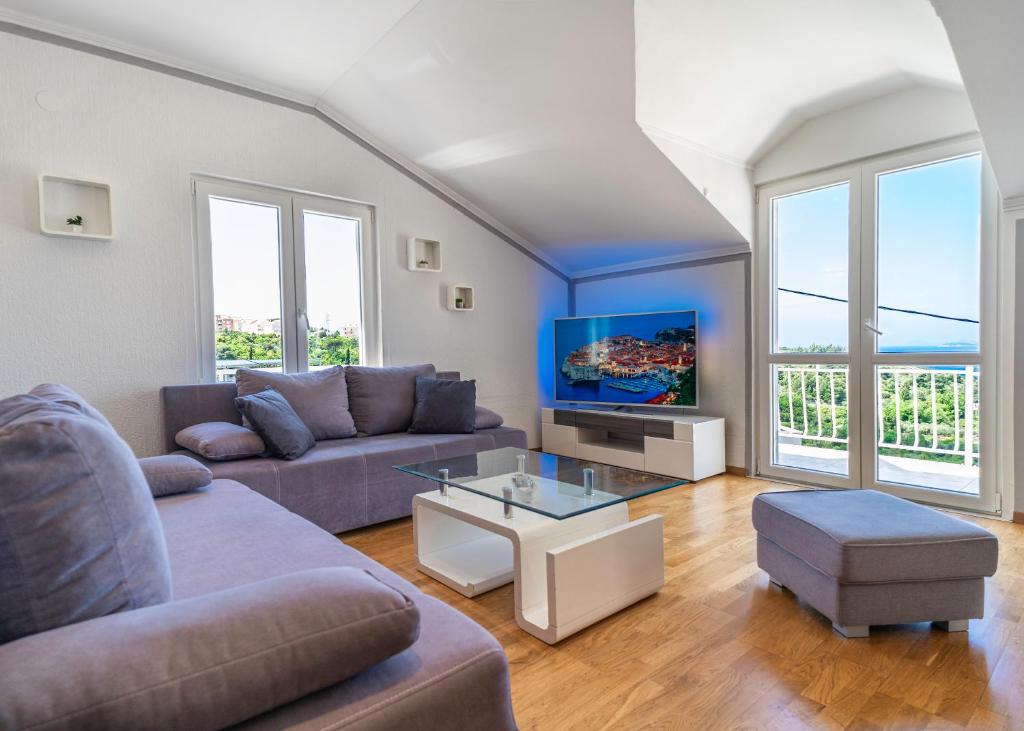 sala de estar con sofá y TV en Apartments Ines, en Cavtat