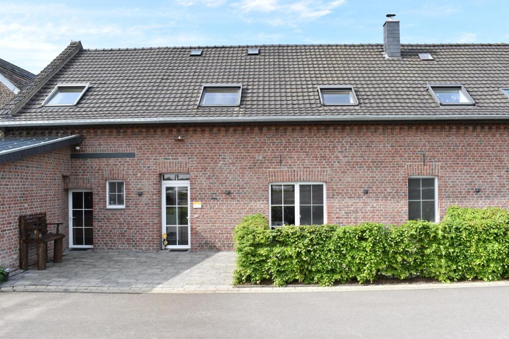 a red brick building with windows and a roof at Ferienwohnung Kerstenhof in Willich