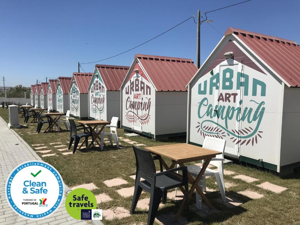a row of beach huts with tables and chairs at Urban Art by Campigir in Peniche