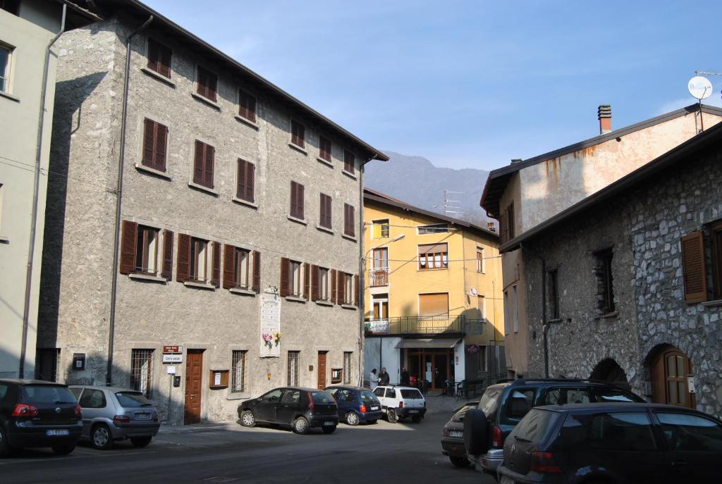 Ono San Pietro的住宿－Ostello Centro Concarena，停在建筑物旁边的街道上的一群汽车