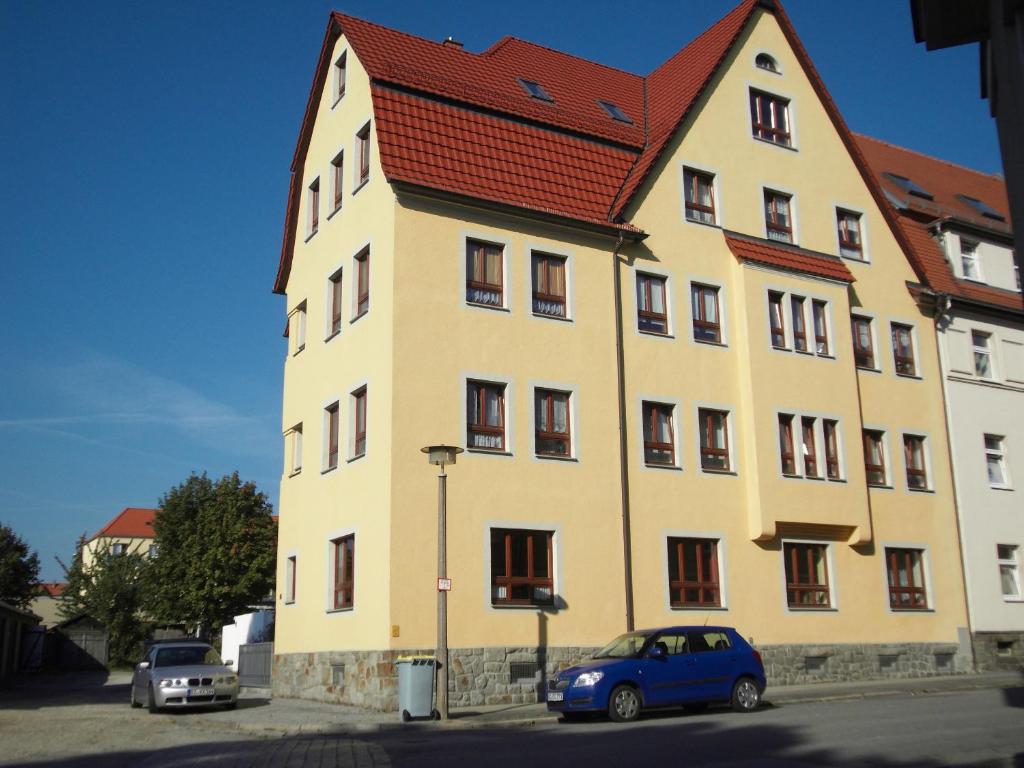 ein großes gelbes Gebäude mit rotem Dach in der Unterkunft Apartment Bautzen-Süd in Bautzen