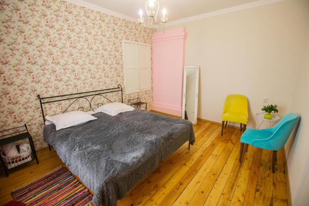 ein Schlafzimmer mit einem Bett und einem gelben Stuhl in der Unterkunft Nino's House in Tsinandali
