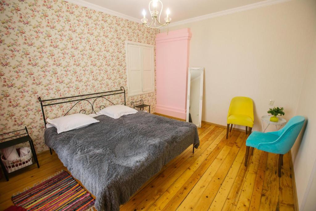 a bedroom with a bed and a yellow chair at Nino's House in Tsinandali