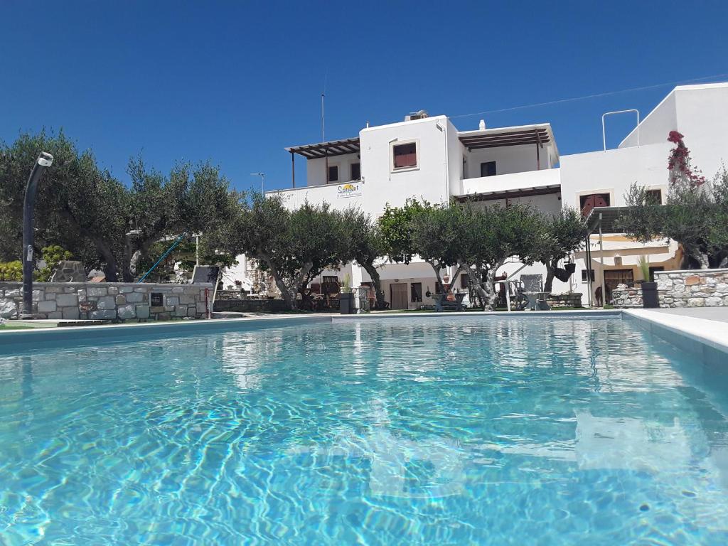 a large swimming pool in front of a house at Sunset studios and apartments for Adults over 21 only in Naousa