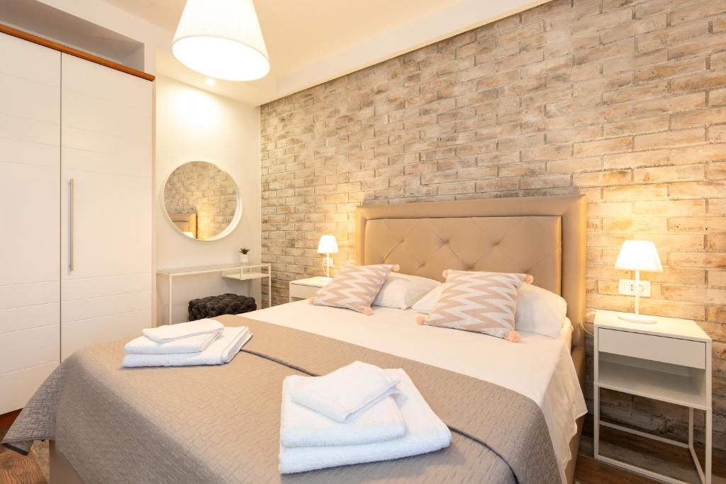 sypialnia z 2 łóżkami i ceglaną ścianą w obiekcie Ela w mieście Rijeka