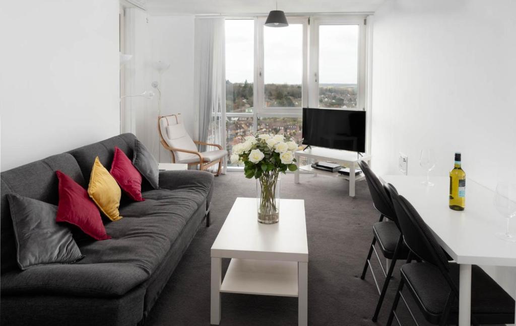 a living room with a couch and a table with a vase of flowers at Abodebed KD Tower in Hemel Hempstead