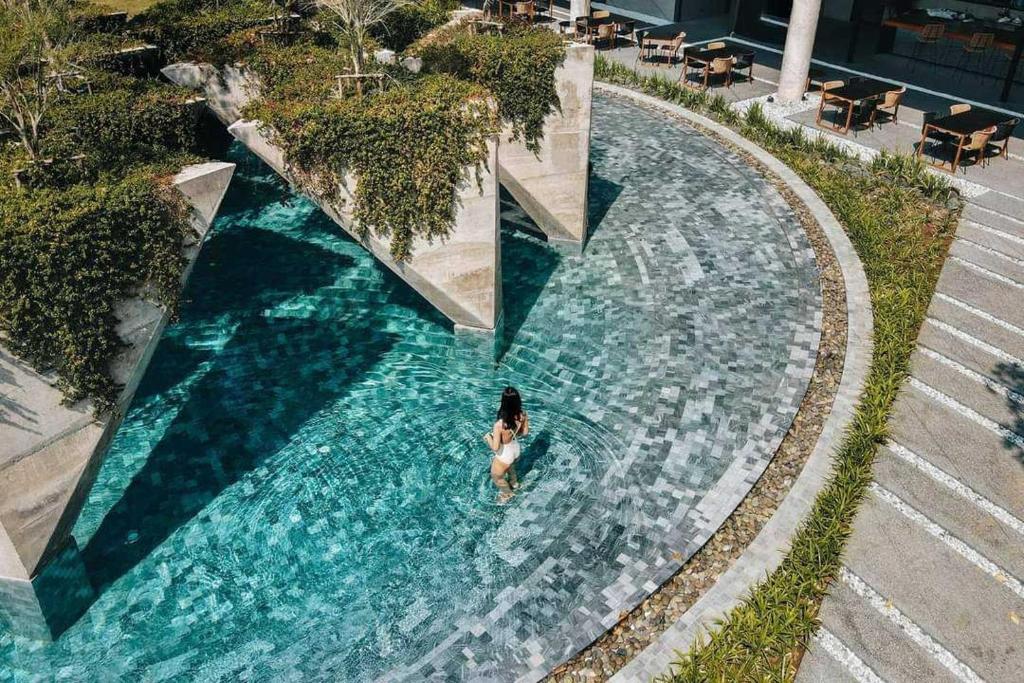 a person swimming in a pool of water at Livist Resort phetchabun in Phetchabun