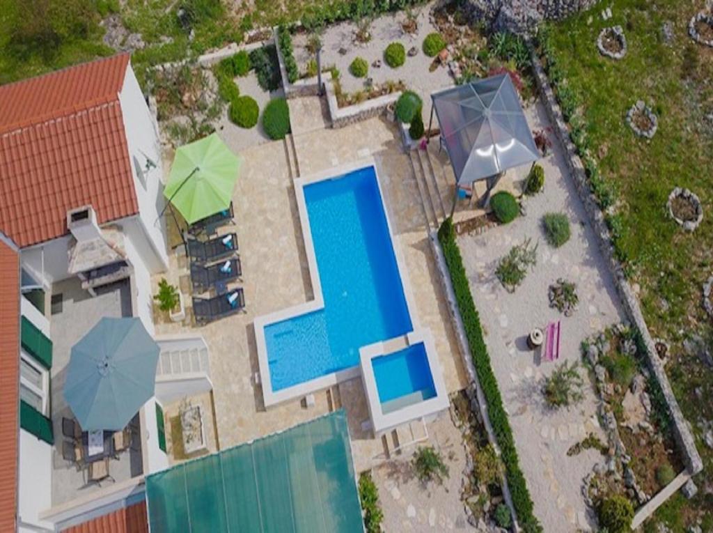 una vista aérea de una piscina y sombrillas en Holiday Home Ela en Dračevica