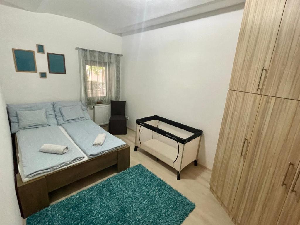 Schlafzimmer mit einem Bett und einer Tür mit einem Teppich in der Unterkunft Árvíz Apartman in Szeged
