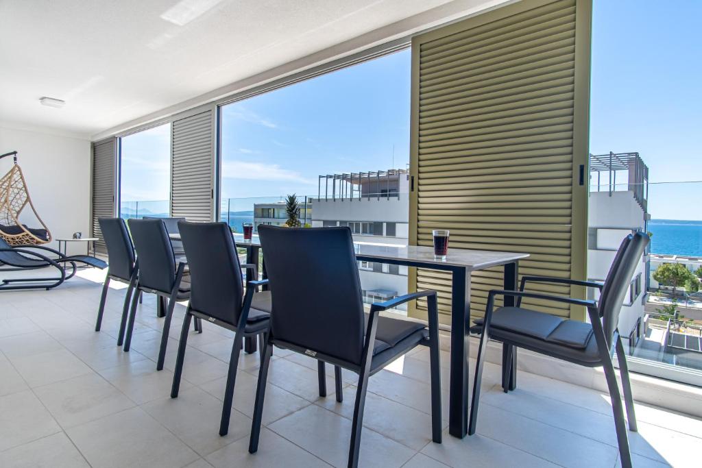 a dining room with a table and chairs and the ocean at Euphoria Luxury Apartment in Split
