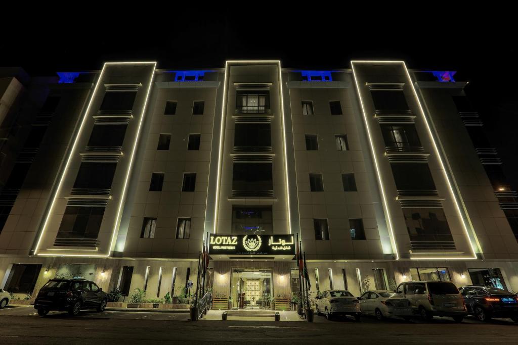 un edificio con coches aparcados delante de él por la noche en Lotaz Hotel Suites - Al Salamah en Yeda