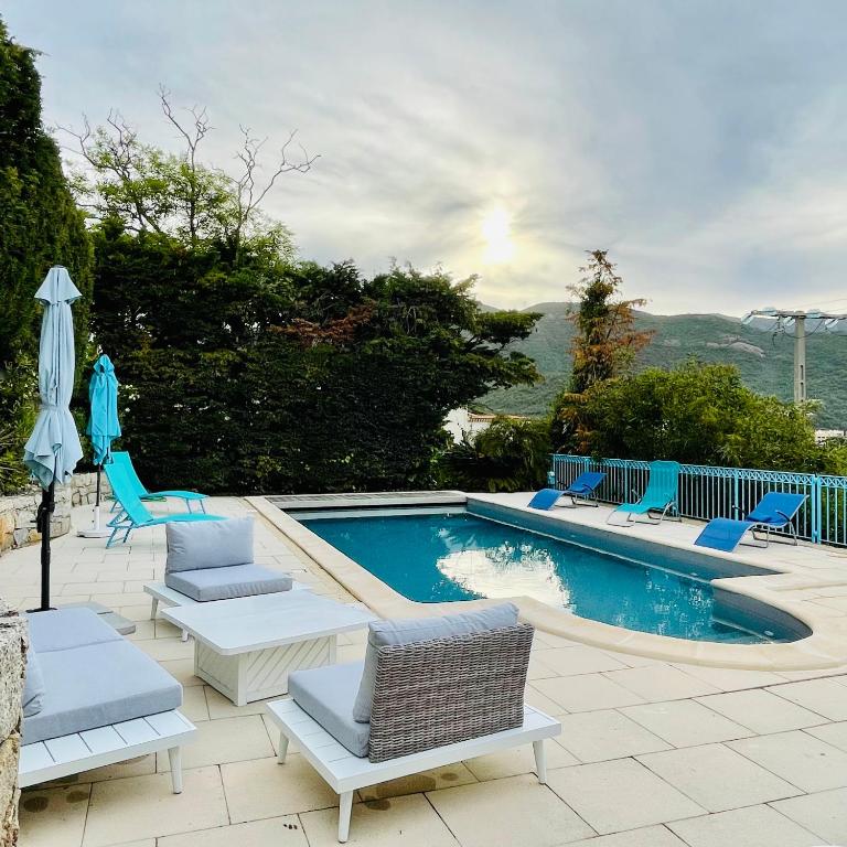 a swimming pool with chairs and an umbrella at Villa Turquoise Sagone in Sagone