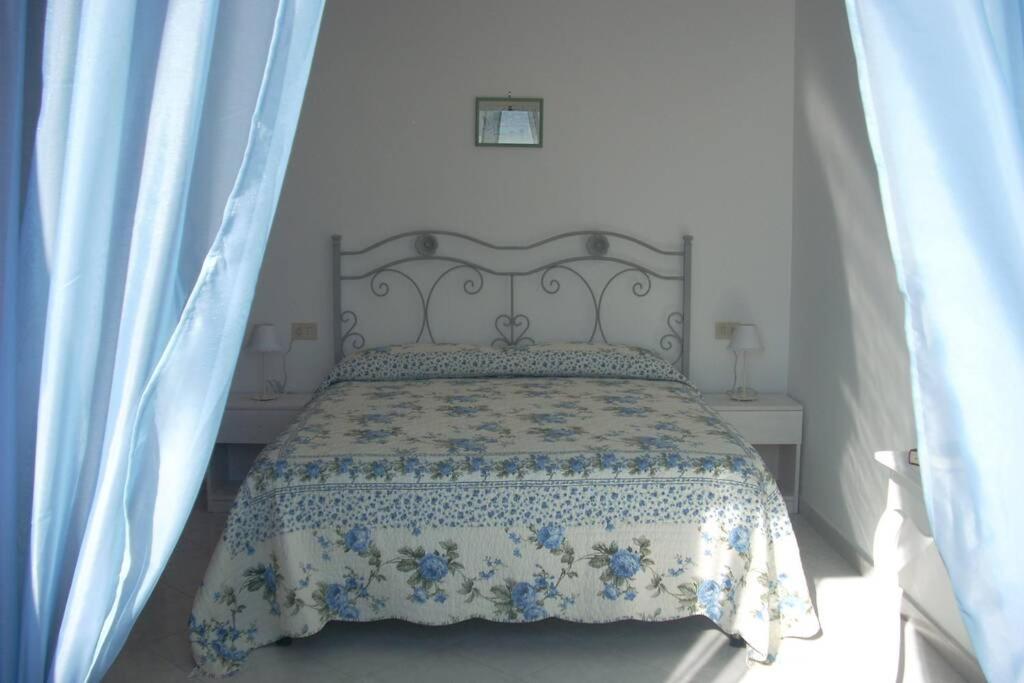 um quarto com uma cama com um edredão azul e branco em Sea&sky em Praiano