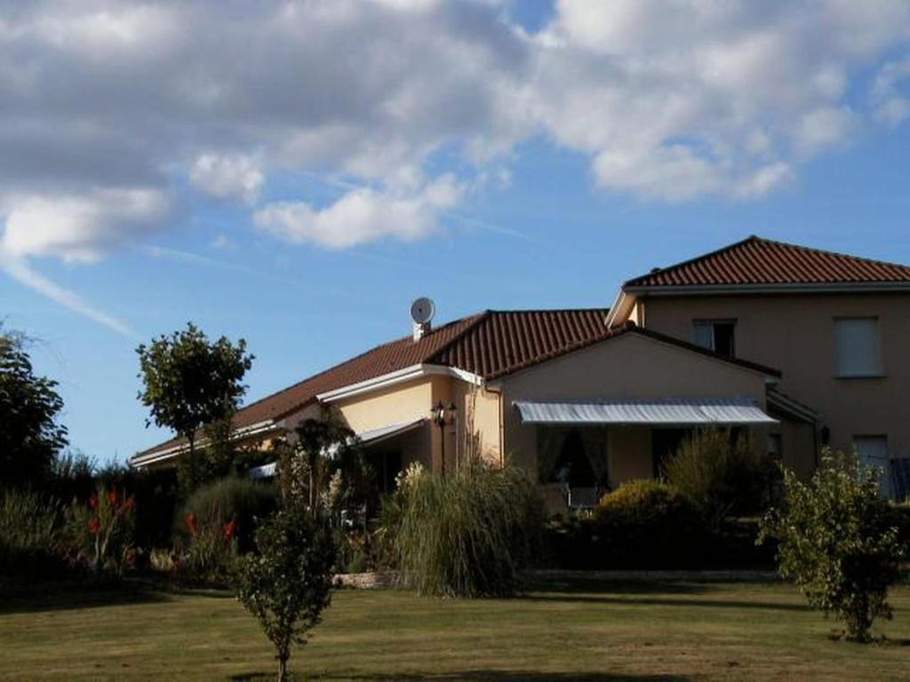 a house with a grass yard in front of it at Chambres d'Hôtes de l'Auraine in Limoges