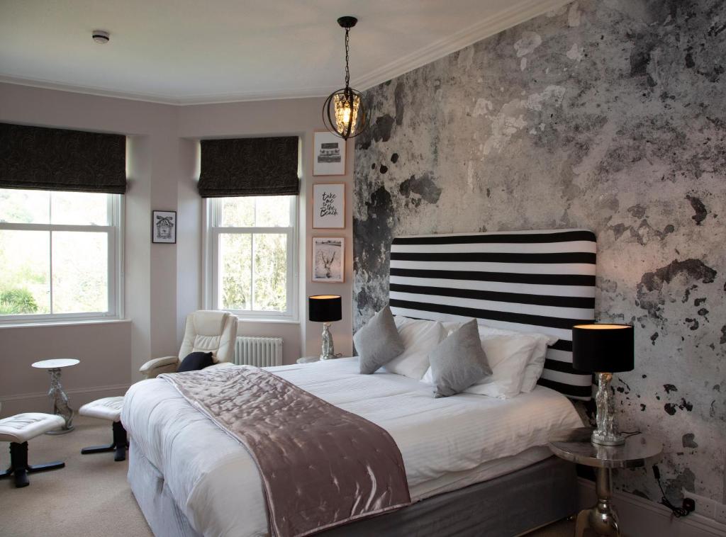 a bedroom with a large bed with a black and white headboard at Carlton Court in Torquay