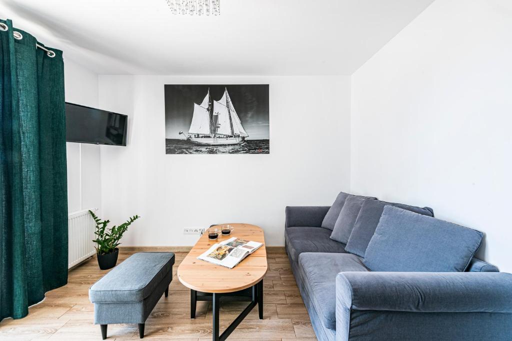a living room with a couch and a coffee table at Apartament Zielony OPTILOCUS in Gdańsk