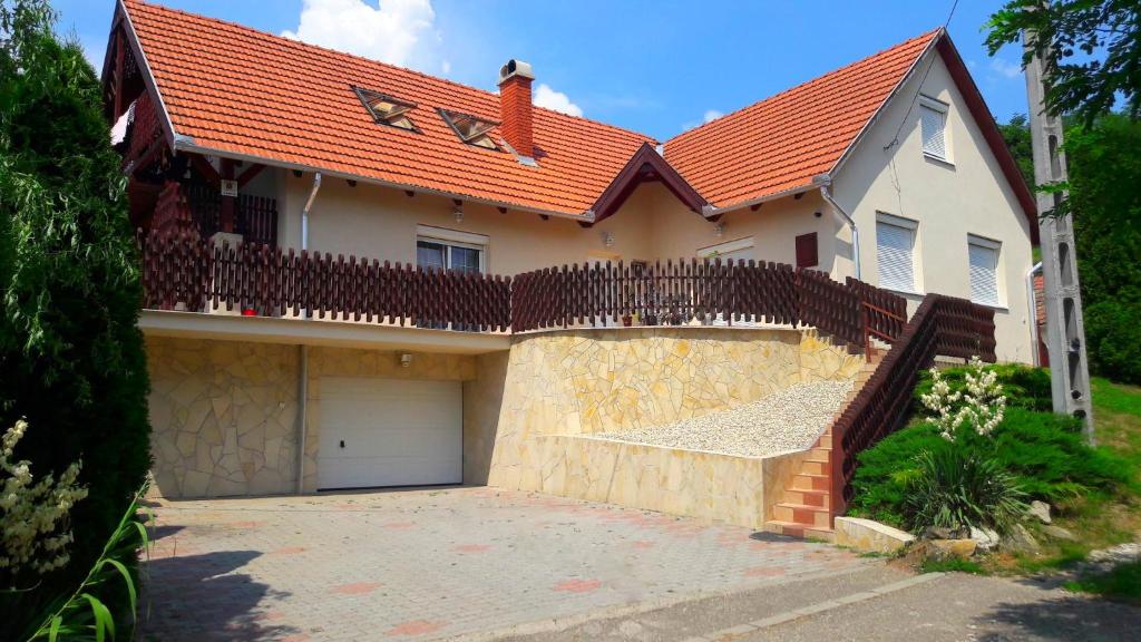 a house with a garage and a red roof at Sókristály Vendégház in Demjén