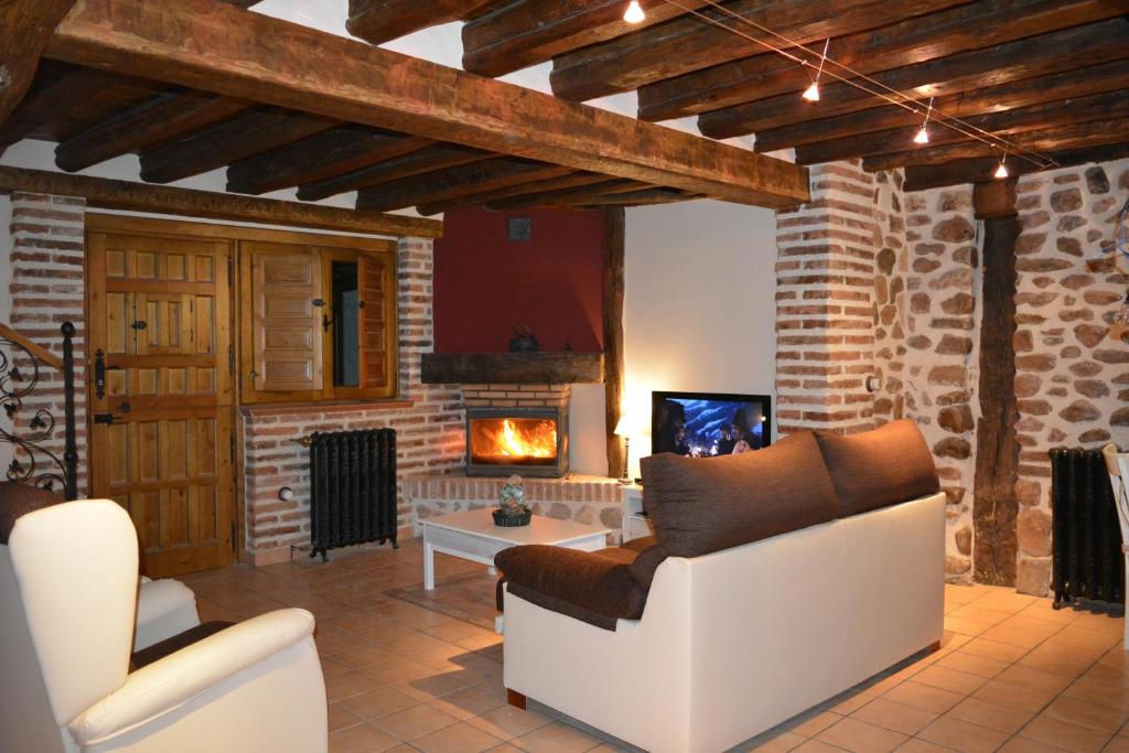 sala de estar con sofá y chimenea en La Casa de Villar en Villar de Torre