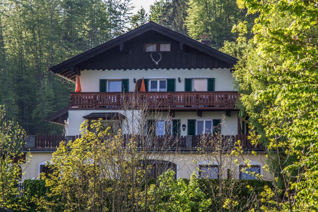 ein großes weißes Haus mit einem Gameradach in der Unterkunft Haus Bergland in St. Wolfgang