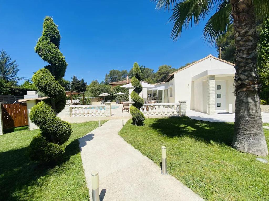 een huis met een palmboom en een loopbrug bij Villa FG in Mougins