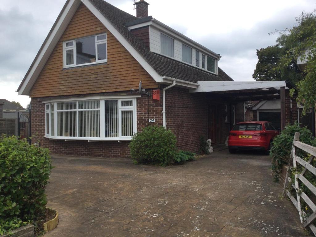 a house with a car parked in the driveway at Comfort House in Havant