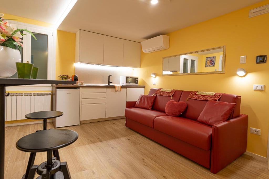 Il comprend un salon avec un canapé rouge et une cuisine. dans l'établissement NINA SWEET HOME IN VENICE, à Venise