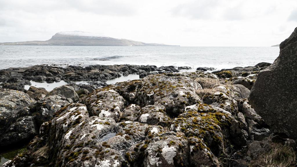 
a rocky shoreline with rocks and boulders at Hotel Djurhuus in Tórshavn
