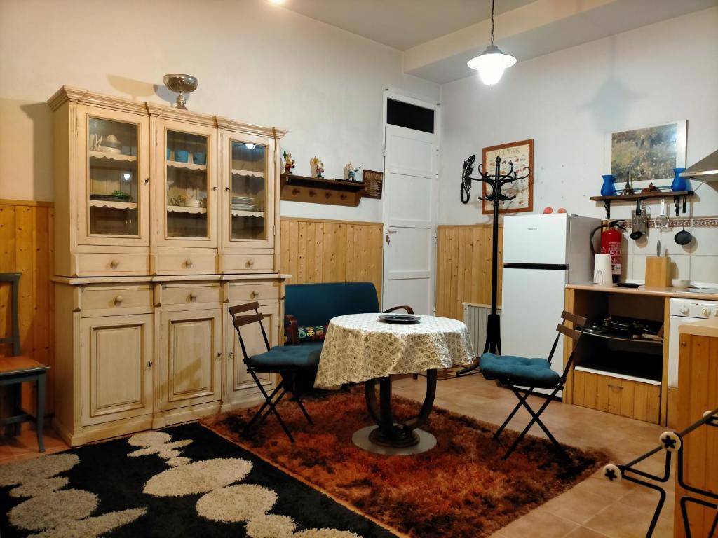 a kitchen with a table and chairs and a refrigerator at ALL IN ONE. TODO EN UNO. in Bérriz