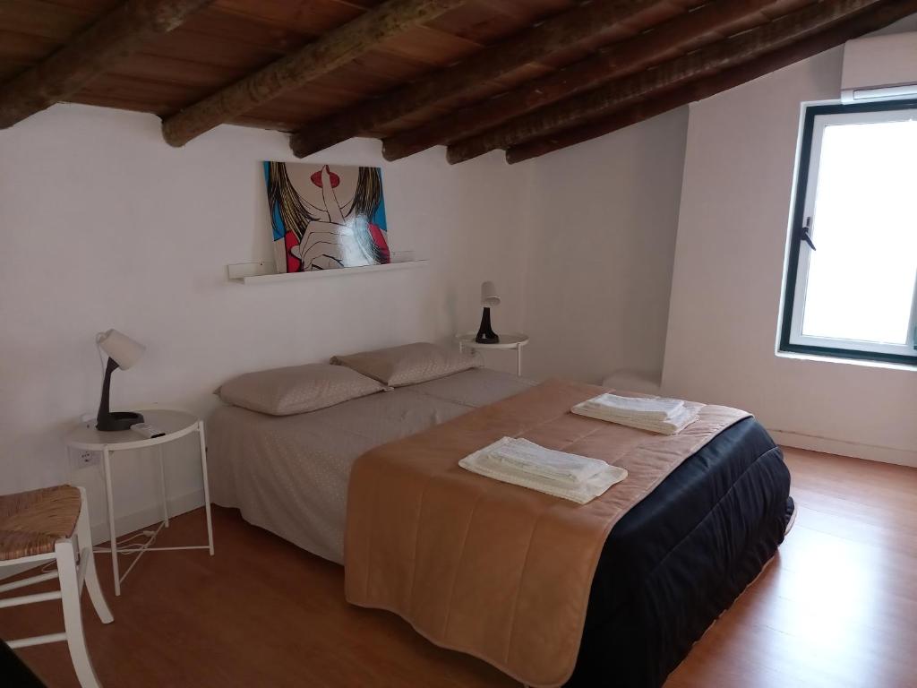una camera da letto con un letto con due asciugamani sopra di Guest House Páteo da Cadeia Velha a Serpa
