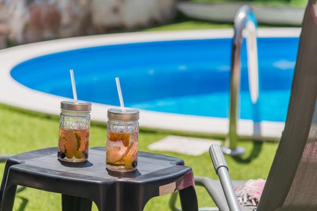 due barattoli in muratura su un tavolo vicino a una piscina di Holiday home Giovanni a Solin (Salona)
