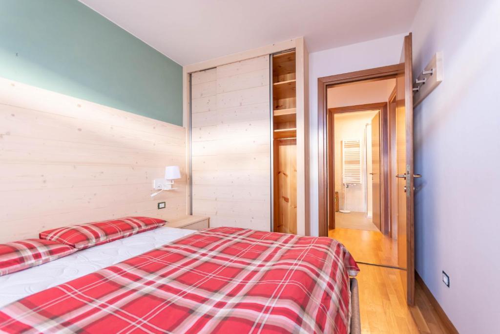 Schlafzimmer mit einem Bett mit einer roten und weißen Decke in der Unterkunft Casa Piz Meda in Soraga