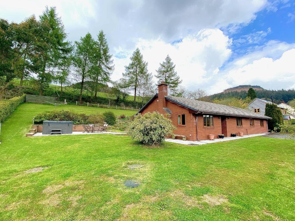 a red brick house with a large grass yard at Erw Fair in Rhayader