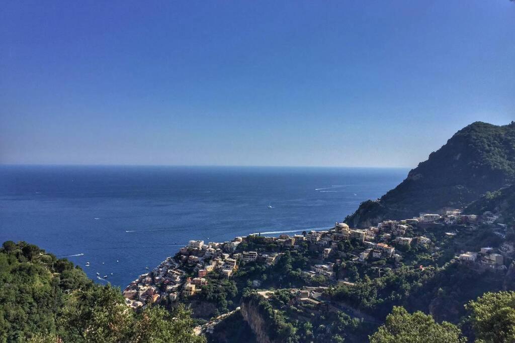 a village on a mountain with the ocean in the background at Casa Ministro in Positano