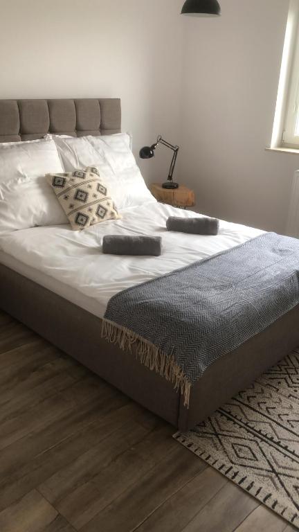 a bed with two remote controls on top of it at Apartament Gościnne Sady in Malbork