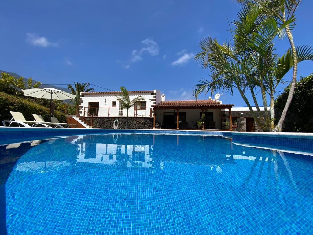 una gran piscina azul frente a una casa en Villamocanes en Frontera
