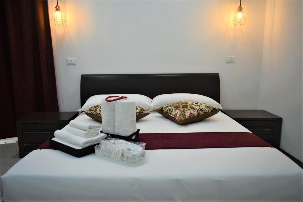 um quarto com uma cama branca com toalhas e almofadas em Affittacamere Dianir em Roma