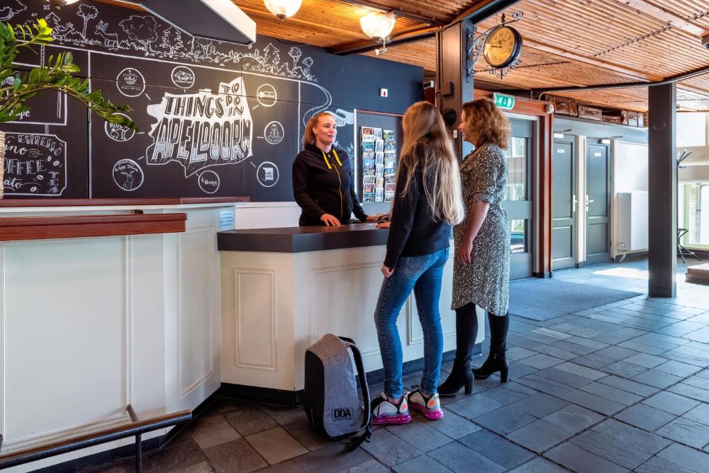 Dos mujeres de pie en un mostrador en un restaurante. en Stayokay Hostel Apeldoorn, en Apeldoorn