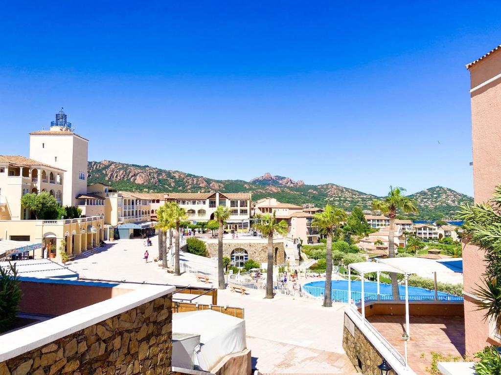 a view of a resort with a pool and palm trees at Residence Cap Esterel Babou in Saint-Raphaël