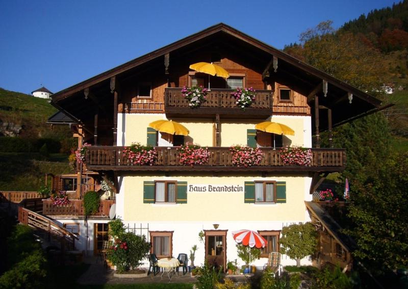 a building with a balcony with umbrellas on it at Haus Brandstein Ferienwohnungen in Ramsau