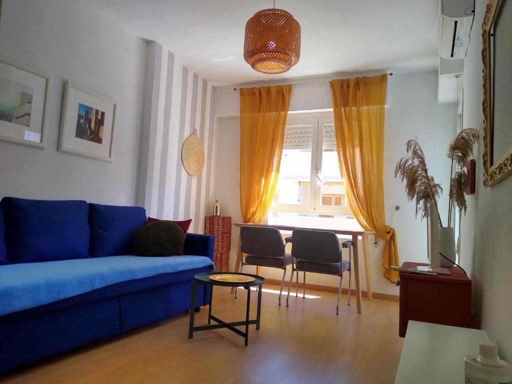 a living room with a blue couch and a table at Apartment Sol de Santa Pola in Santa Pola