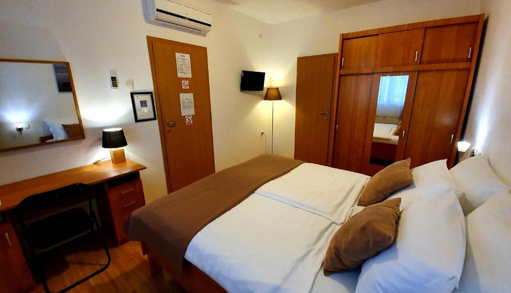 a bedroom with a large bed with a desk and a bed sidx sidx sidx at Adriasobe in Vodice