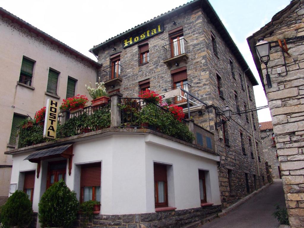 um edifício com uma varanda com flores em Hostal Pirineos Sarvisé em Sarvisé