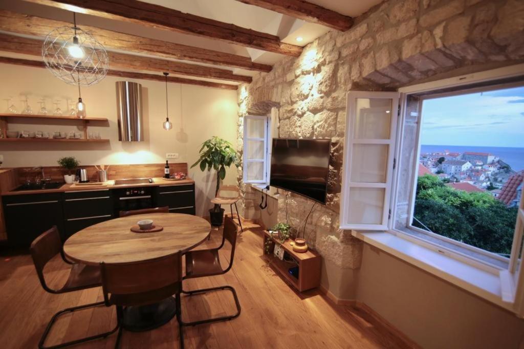 
a living room with a table, chairs and a window at Apartments Cava Dubrovnik in Dubrovnik
