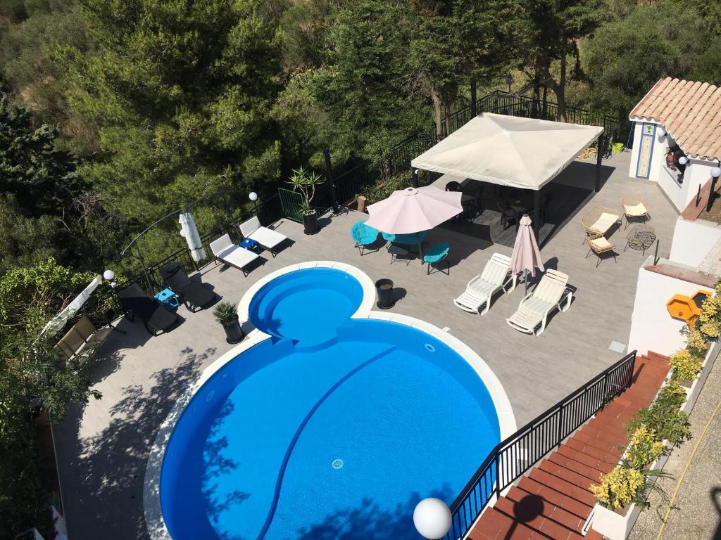una vista sul soffitto di una piscina con sedie e ombrelloni di Gibilrossa BeeHill a Misilmeri