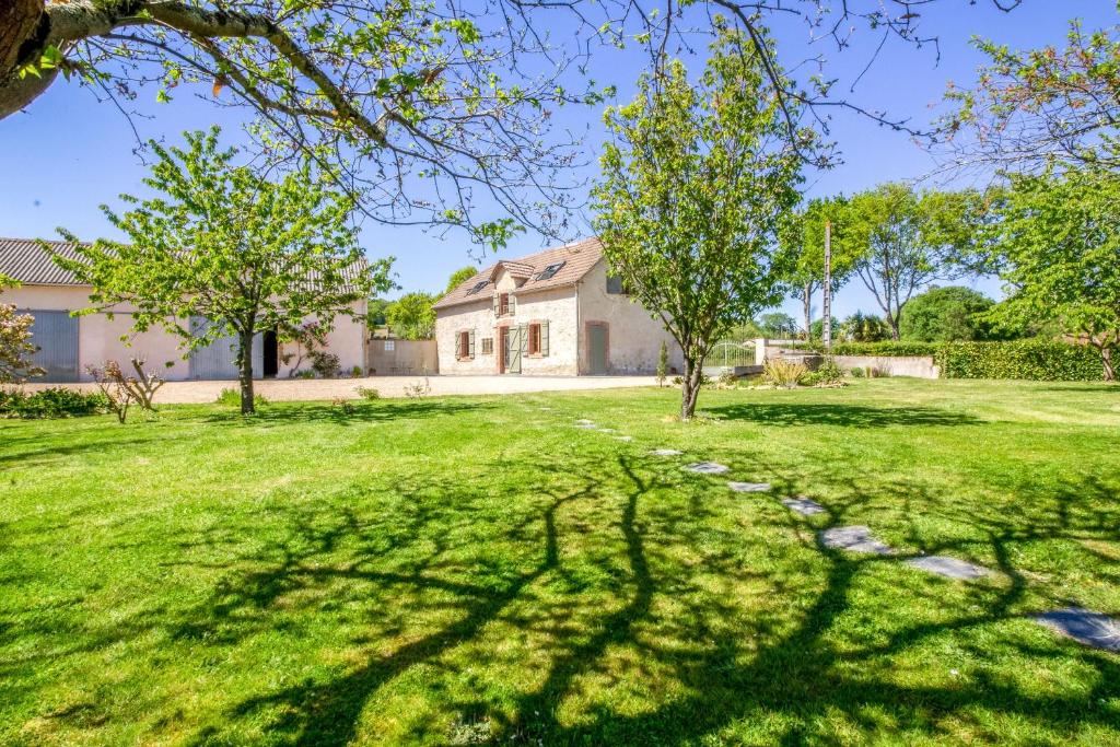 un patio con árboles y una casa en Ecogite Rural La Cle des Champs, en Peyrelongue-Abos