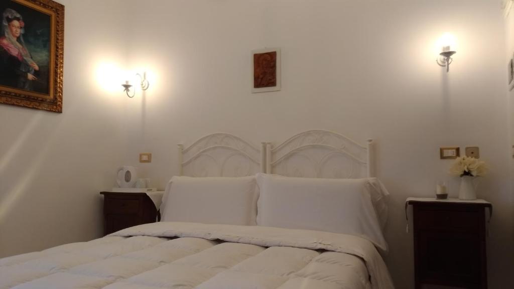 a bedroom with a white bed with white pillows at B&B DIMORA PALMIERI in Monopoli