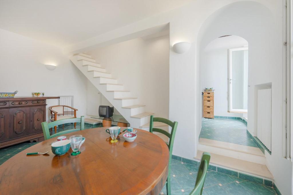 jadalnia z drewnianym stołem i zielonymi krzesłami w obiekcie Casa Ventrosa, Anacapri w mieście Anacapri