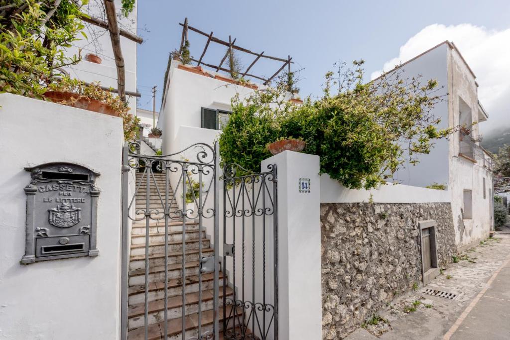 a white house with a gate and a stone wall at Casa Ventrosa, Anacapri in Anacapri